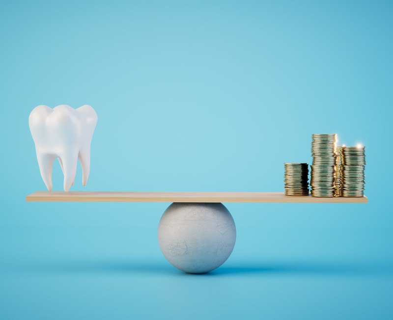 A balance beam supporting a model tooth and stacks of coins