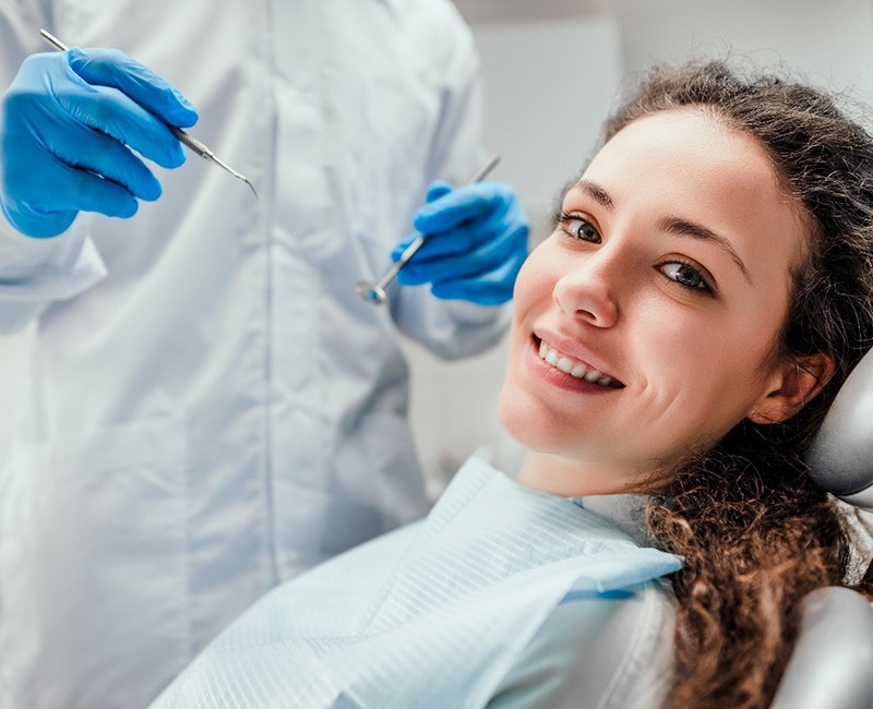 woman smiling while sitting in dental chair 