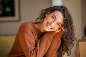 Smiling woman resting her head on her hands